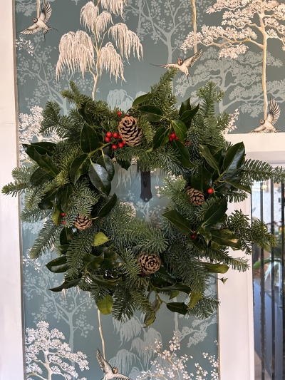 Holly Wreath - A traditional Holly Wreath dressed with pine cones, bringing together spruce, rich red berries and rustic woodland charm for a timeless Christmas look.