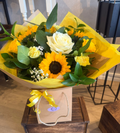 Sunshine Bouquet - A cheerful bouquet of sunflowers, white roses and soft yellow blooms, hand-arranged with fresh greenery to brighten their day and lift any space.